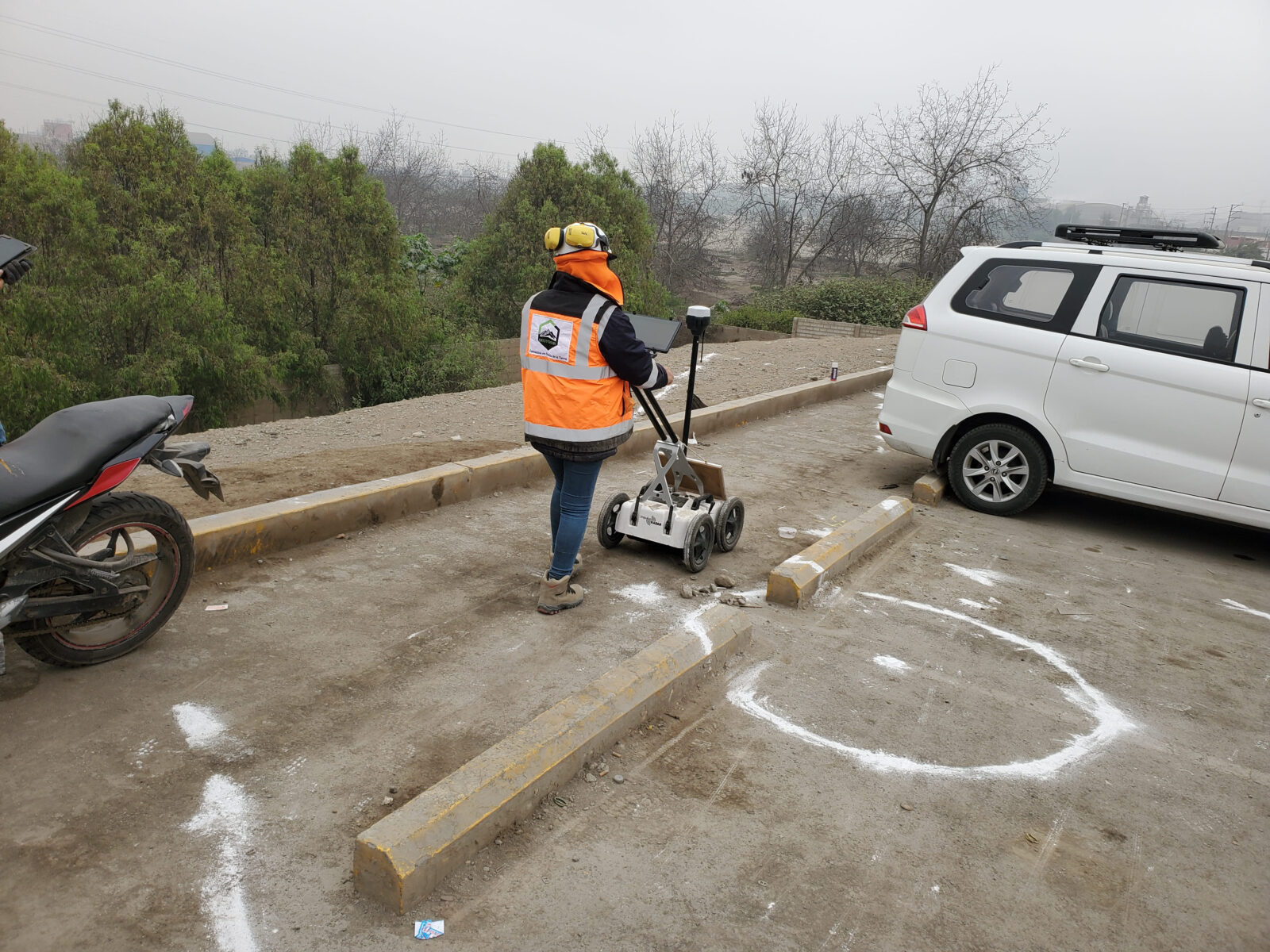 Operadora usando equipo de georradar sobre pavimento marcado con señalización