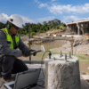 Técnico realizando un ensayo de integridad de pilotes en una obra de infraestructura.