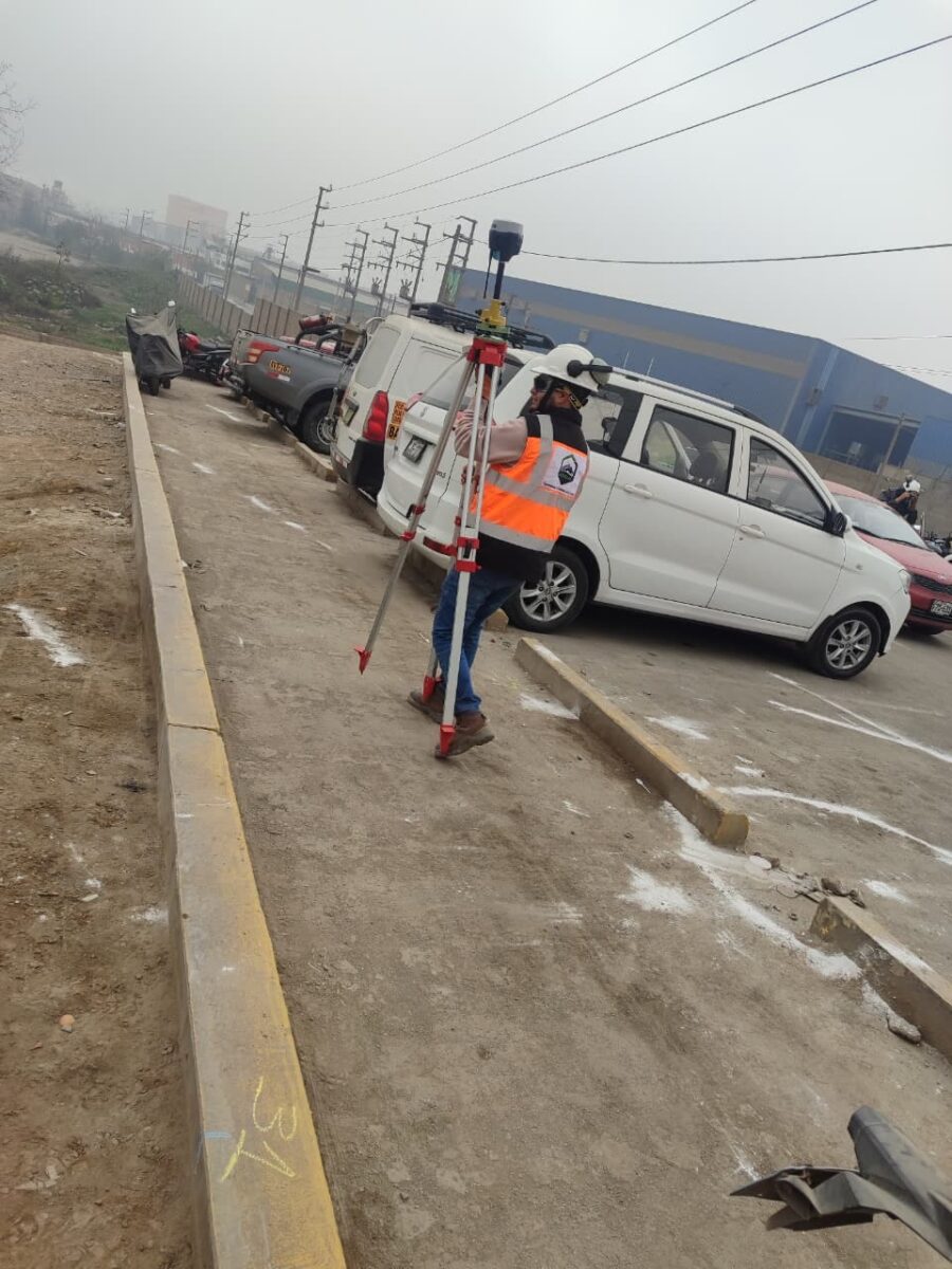 Técnico georreferenciando línea de exploración con GPS en vía de concreto